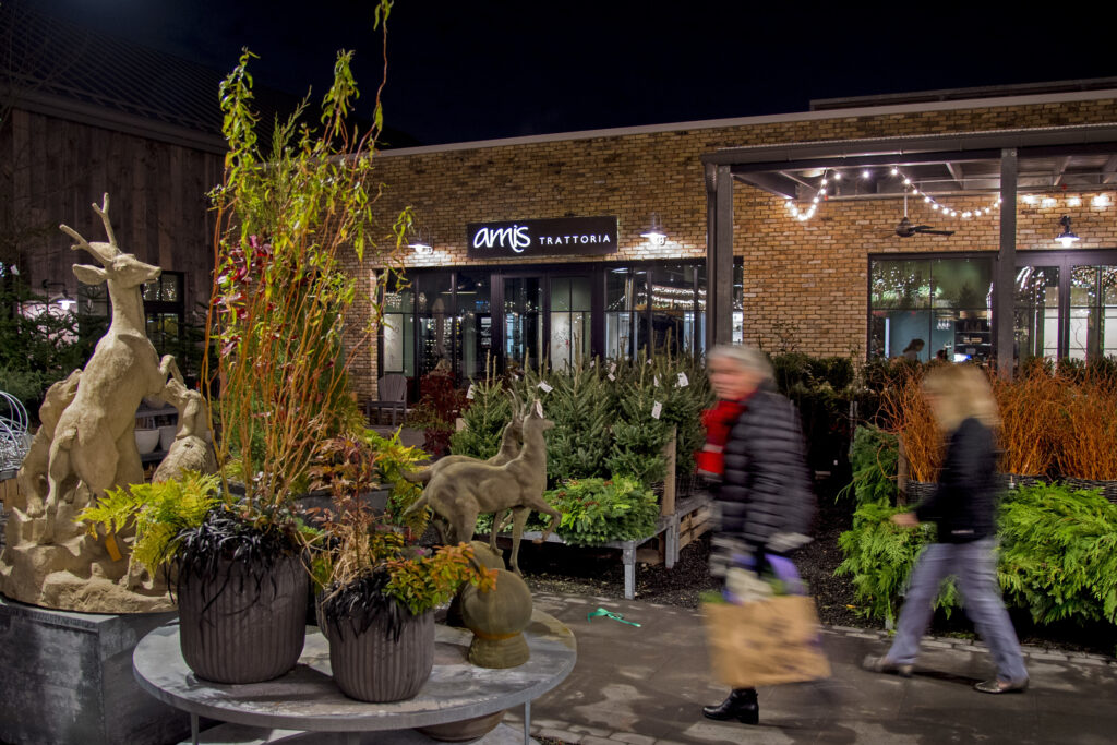 Shoppers pass between the yard and garden ware at Terrain (left) and Amis Trattoria (rear) in Devon Yard, the Urban Outfitters Multi-Brand Retail Complex In Devon November 19, 2018. TOM GRALISH / Staff Photographer